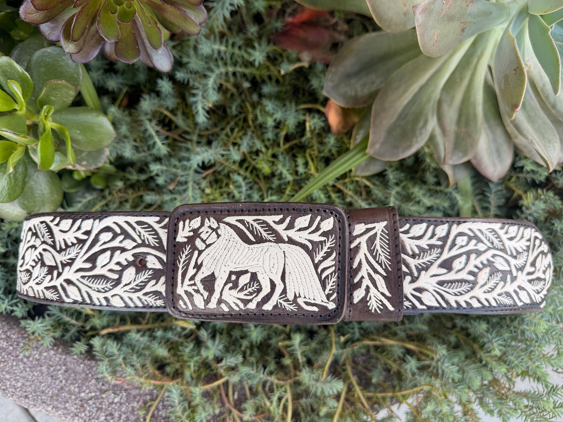 Decorative belt with animal design on a green plant background